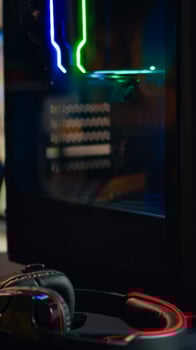 Powerful gaming unit with colorful RGB lights prepared for gaming tournament in living room at night. Cyber performing in stylish room playing online shooter game. photo