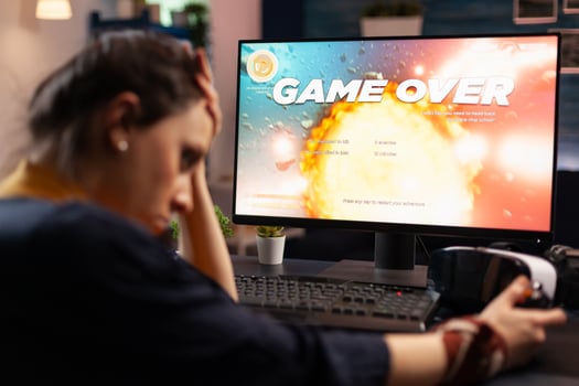 Frustrated woman losing online games on computer. Disappointed person playing on monitor, using controller and feeling sad about lost game. Gamer with electronic e sport. photo