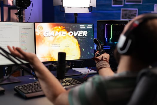 Player streaming games with headset and losing on computer. Man looking at monitors with live stream chat and online game, playing and broadcasting gameplay with microphone. photo