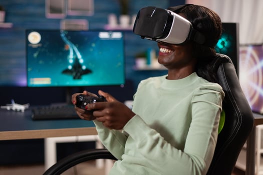 Focused african american pro gamer woman with virtual reality googles playing space shooter videogames using gaming controller during online tournament. RGB computer equipment. Cyber space photo