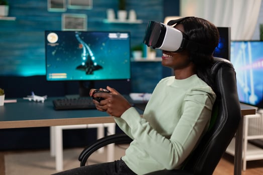 Pro gamer woman wearing virtual reality googles holding gaming controller playing space shooter videogames during online competition. Concentrated gamer playing games using RBG computer equipment photo