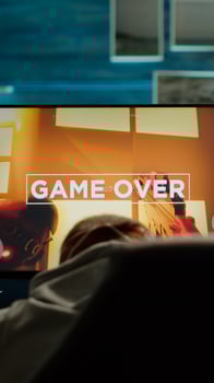 Back view of sad professional eSports gamer losing shooter mock-up game. Defeated man with headphones streaming online cyber performing during gaming tournament using powerful personal computer photo