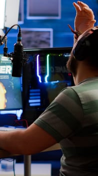 Videogame streamer losing online videogame competition wearing professional headset talking on stream chat. Sad gamer using powerful computer for gaming tournament late night playing space shooter game photo