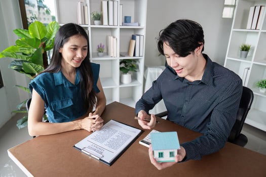 Real Estate Agent Buy Sell Contract Signing with Happy Clients and Agent in Modern Office Environment photo