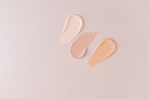 Three beautiful samples of foundation powder of different tones on a beige background with a copy space. Delicate texture of foundation . top view. photo