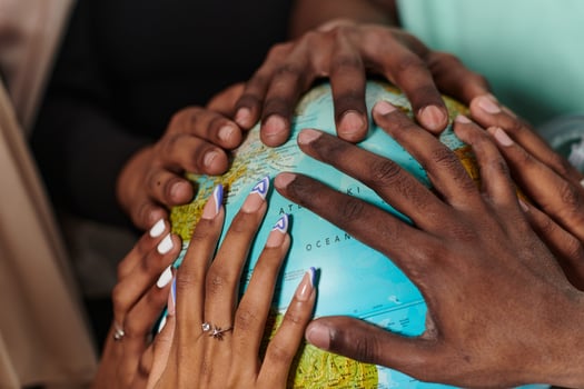 Close up of diverse teenagers' hands delicately exploring a globe, capturing the essence of curiosity and exploration in their tactile engagement with geographical knowledge photo