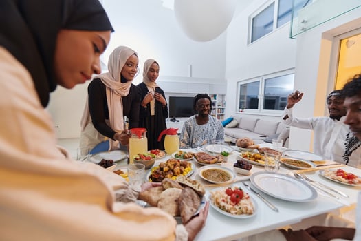 In the sacred month of Ramadan, a Muslim family joyously comes together around a table, eagerly awaiting the communal iftar, engaging in the preparation of a shared meal, and uniting in anticipation photo