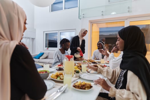 In the sacred month of Ramadan, a Muslim family joyously comes together around a table, eagerly awaiting the communal iftar, engaging in the preparation of a shared meal, and uniting in anticipation photo
