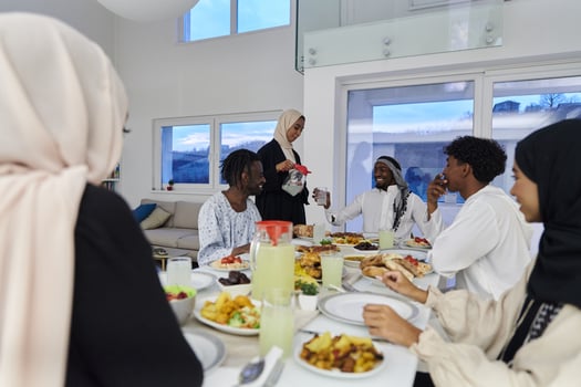 In the sacred month of Ramadan, a Muslim family joyously comes together around a table, eagerly awaiting the communal iftar, engaging in the preparation of a shared meal, and uniting in anticipation photo