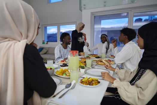 In the sacred month of Ramadan, a Muslim family joyously comes together around a table, eagerly awaiting the communal iftar, engaging in the preparation of a shared meal, and uniting in anticipation photo