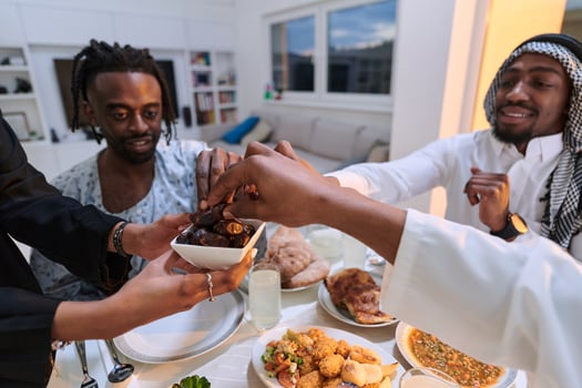 In a poignant close-up, the diverse hands of a Muslim family delicately grasp fresh dates, symbolizing the breaking of the fast during the holy month of Ramadan, capturing a moment of cultural unity photo