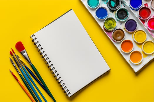 watercolor paints and brushes with notebook photo