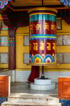 Buddhist monk rotating big prayer wheel photo