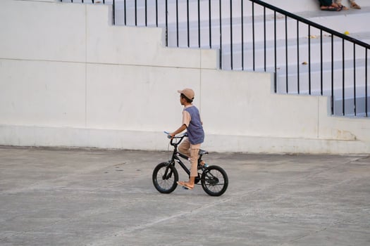 Jakarta, Indonesia, 2024 - Boy Riding Bicycle on Urban Path, Lapangan Banteng Park Cycling photo