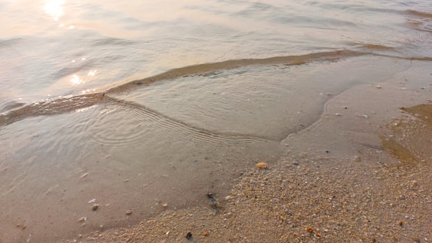 Close up soft wave lapped the sandy beach. natural abstract background and texture photo