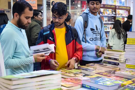 Delhi, India, June 17 2024 - Various age group people reading variety of Books on shelf inside a book-stall at Delhi International Book Fair, Books in Annual Book Fair at Bharat Mandapam complex photo
