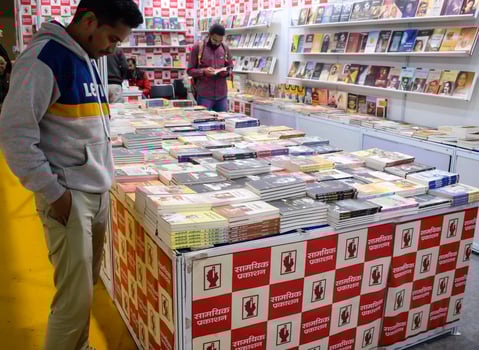 Delhi, India, June 17 2024 - Various age group people reading variety of Books on shelf inside a book-stall at Delhi International Book Fair, Books in Annual Book Fair at Bharat Mandapam complex photo