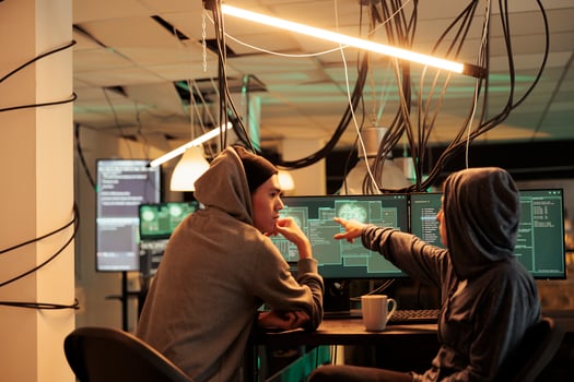 Cybercrime, hackers planning ransomware attack, hacking server, stealing data, discussing illegal malware code. Scammers cracking computer system password at night time, information leak photo