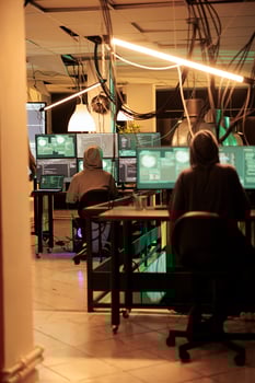 Hackers planting computer malware on software, cracking database password and stealing information for ransom. Having access to online server illegally, cybercrime at night time. photo