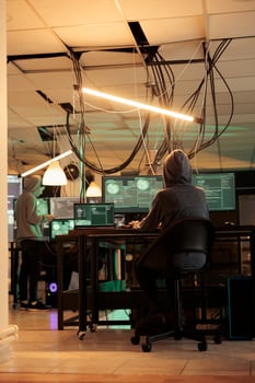Phishing attack, hacker coding internet fraud program script, programming password cracking app on computer. Cyberattack, data breach, woman in hood developing malicious software at night time photo