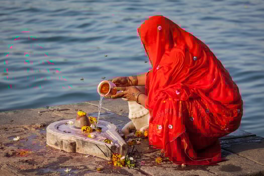 Indian woman performs morning pooja on holy river Narmada ghats photo