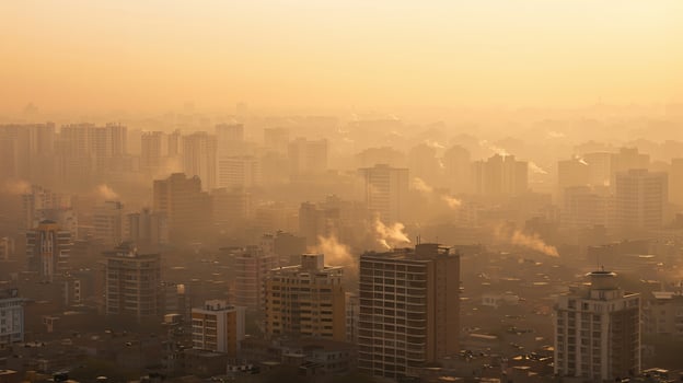 A cityscape shrouded in a yellowish-brown haze of air pollution, highlighting the health risks associated with poor air quality. Air pollution bad ecology photo
