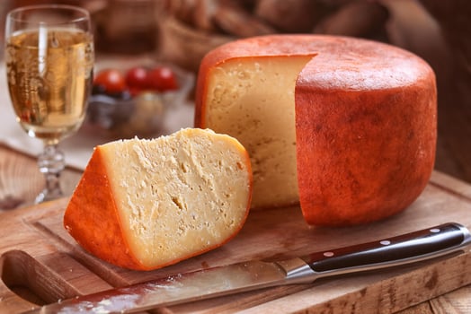 red and yellow cheese - sliced loaf of cheese on a chopping board photo