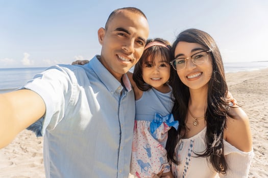 Happy family spending good time at the beach together taking selfie. photo