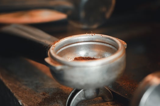 Ground coffee pouring into a portafilter with a grinder photo