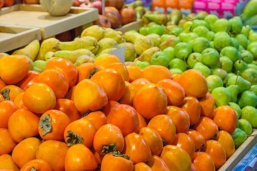 View of a pile of persimmons and pears in the supermarket photo