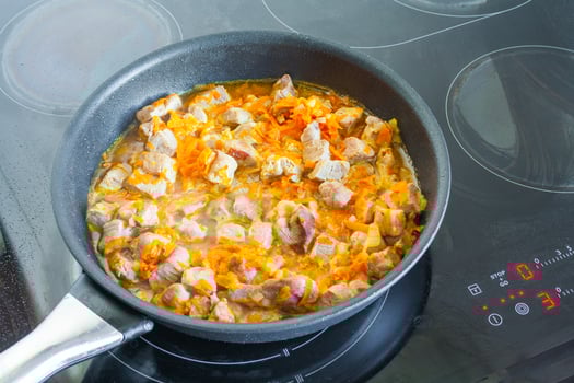 Meat with vegetables is stewed in a frying pan photo