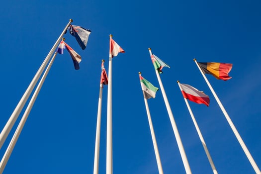 Bottom view of a flags of different countries against a clear blue sky photo