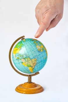 Female hand pointing to a globe. The concept of choosing a place to relax or travel photo