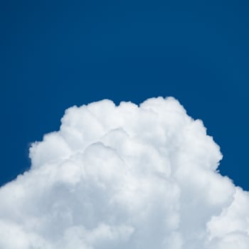 Close up view on a white cumulus fluffy clouds in deep blue sky photo