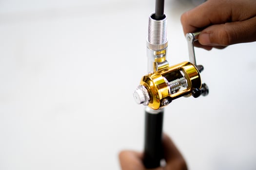 Adjusting a fishing reel on a fishing rod photo