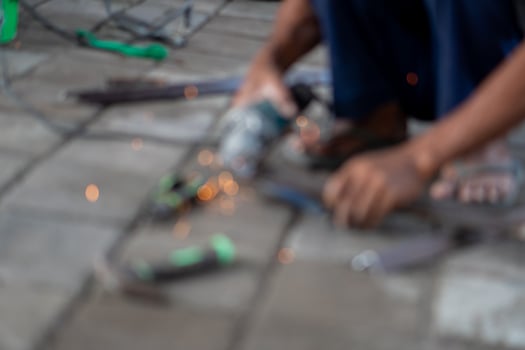 Blurred person using power tool with flying sparks photo