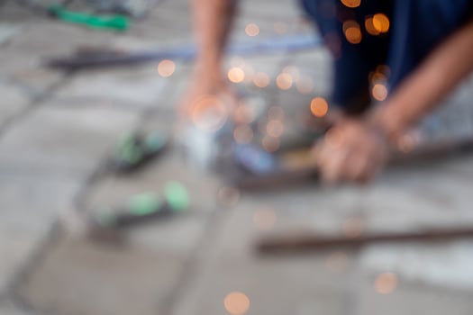 Blurred person using power tool with flying sparks photo