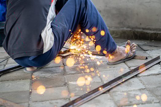 Person welding metal pieces with sparks flying photo