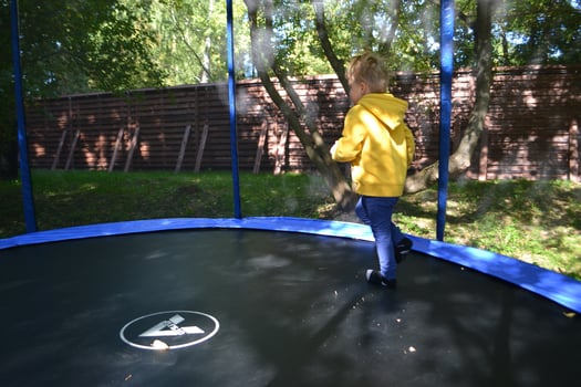 Little boy jumping and having fun on trampoline in amusement center for kids photo