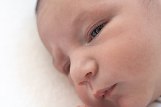 Closeup of a newborn baby's hface on white blanket. photo