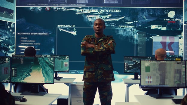 Portrait of national guard commander dressed in military camouflage uniform, team leader overseeing operations in control center. Army officer works on missions at federal agency base. Camera B. photo
