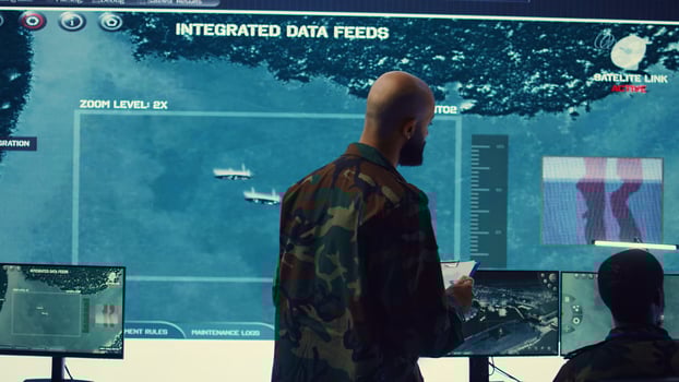 Army officer examining real time satellite data on big screen in military power base, gather intelligence on enemy vessels trajectory. Federal defense program specialist commanding troops. Camera B. photo