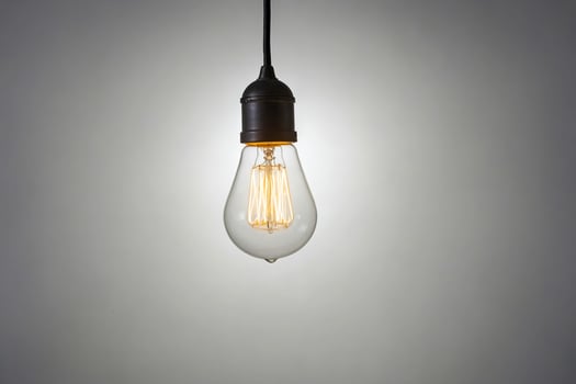 Glowing Light Bulb Hanging from Cord photo