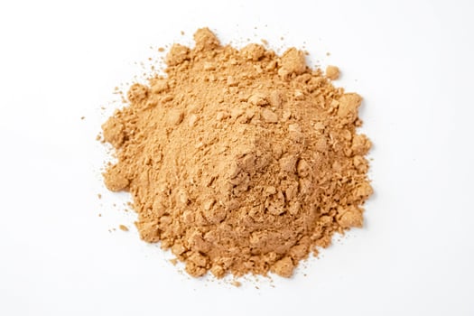 Closeup of a pile of brown powder on a white background photo