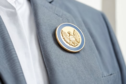 Close up of a golden eagle pin on a blue suit photo