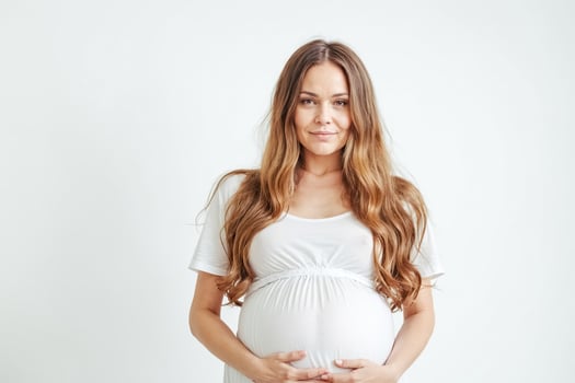 Pregnant Woman Holding Her Belly and Smiling photo