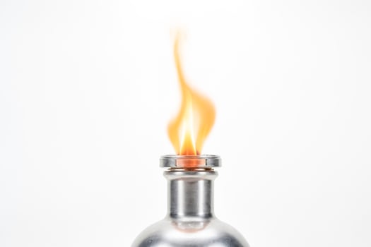 A silver flask with a flame burning from the top photo