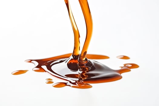 Close Up of Honey Pouring and Dripping onto White Surface photo