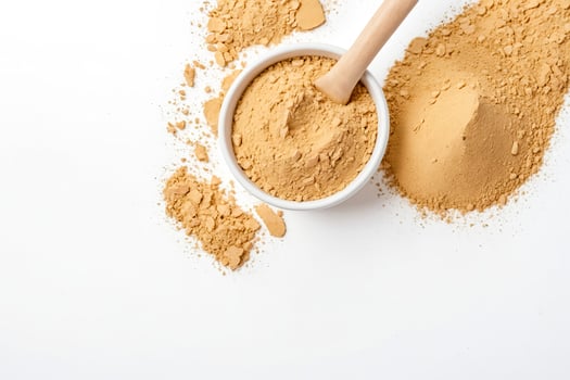 Close-up of Brown Powder in a White Bowl with a Wooden Spoon photo