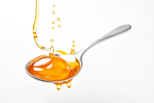 Golden Liquid Dripping From a Spoon photo